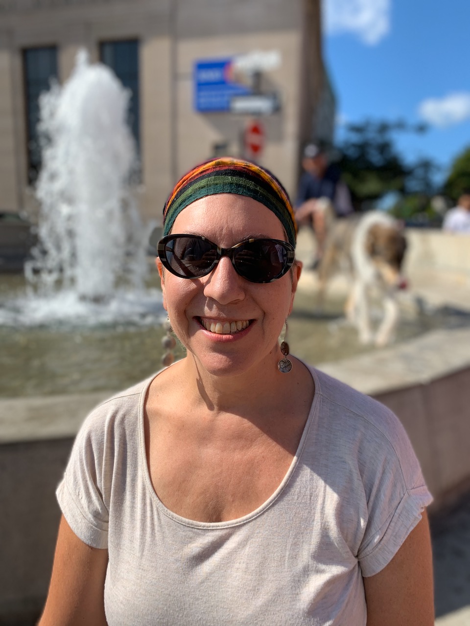 Lynn Barnett smiling outdoors beside a fountain.